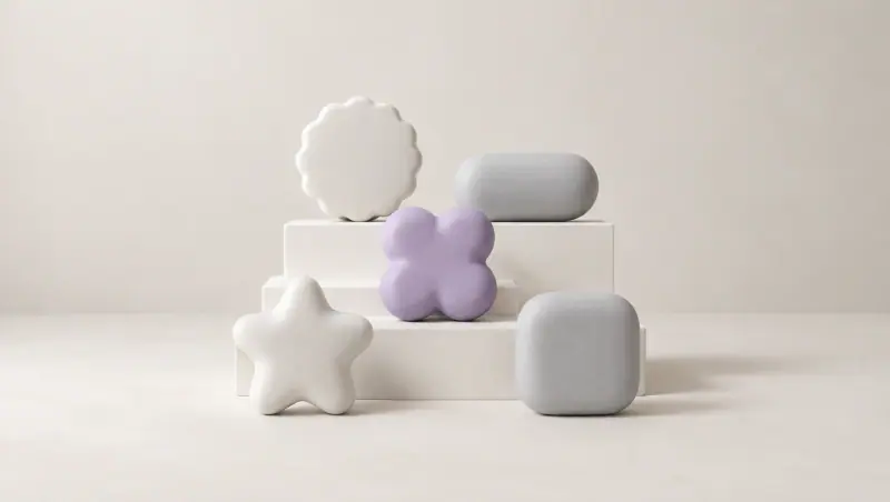 Soft sculpted shapes on low white steps: a scalloped circle, a pill, a star, a rounded square and a lavender four-lobed clover.