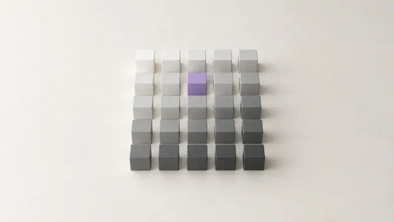 A neat grid of small cubes shading from white to graphite, with a single lavender cube near the top.